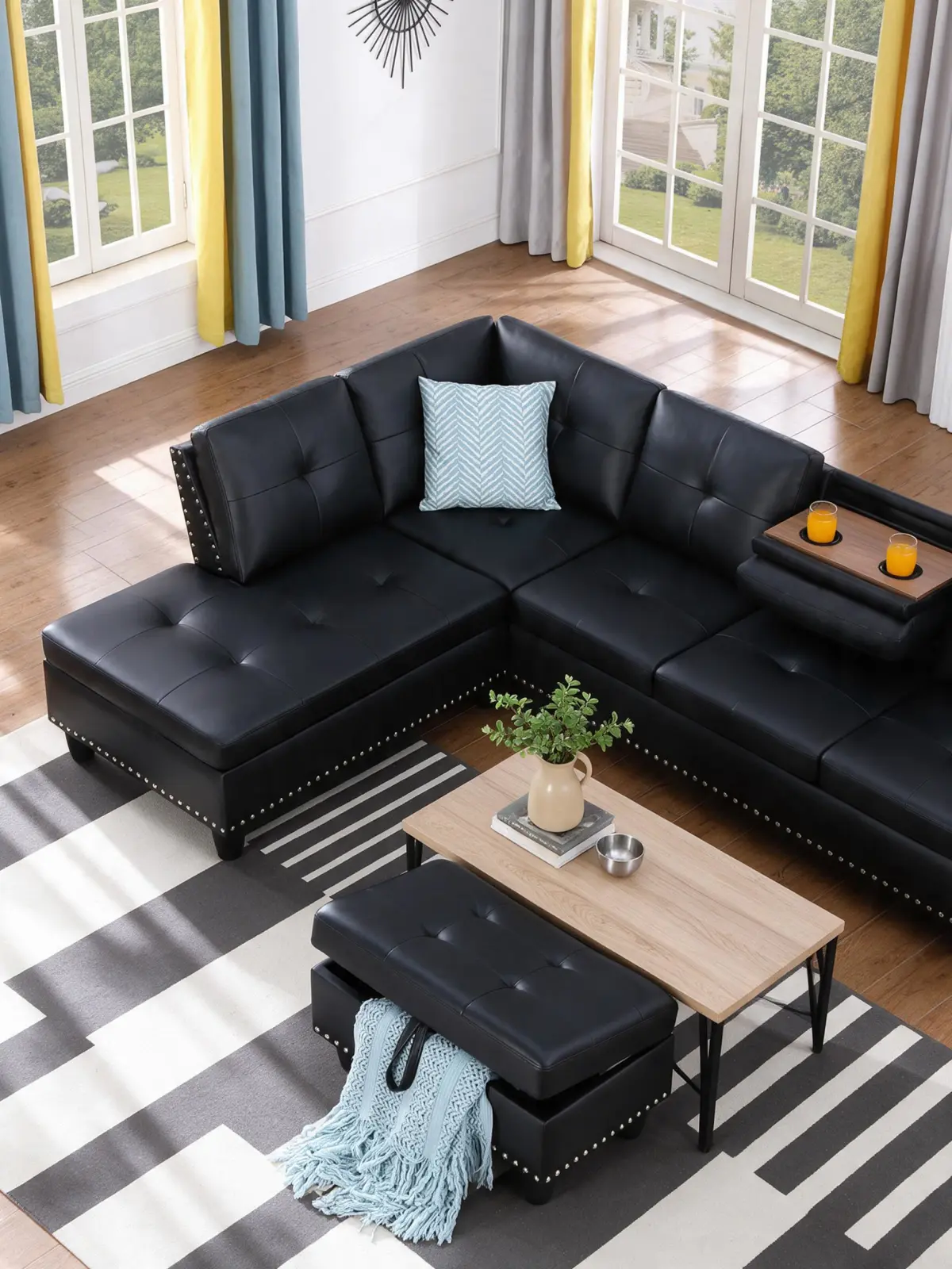Black L-shaped sectional sofa with a wooden coffee table and storage bench in an open living room layout